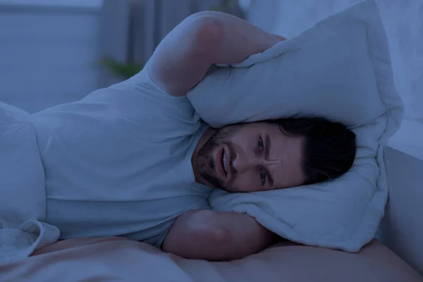 Guy in bed covering his head with pillow — Foto de Stock