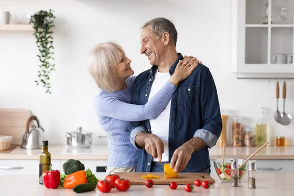Starší milující dvojice, která v kuchyni dělá zdravý salát — Stock fotografie
