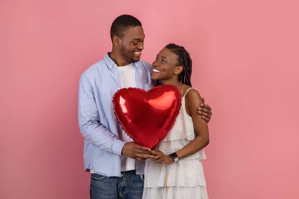 Young Romantic Black Couple Hugging And Holding Heart Shaped Balloon — стоковое фото