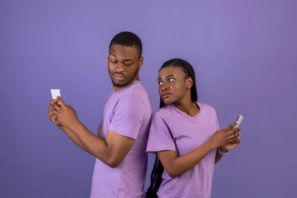 Zwart vrouw controleren zijn vriend mobiele telefoon — Stockfoto