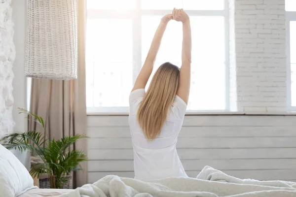 Well-rested blonde woman enjoying happy morning, stretching in bed — Stock Photo, Image