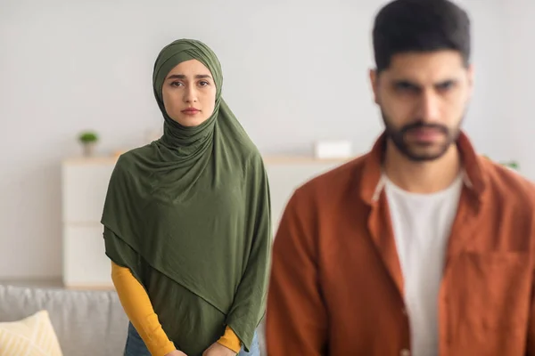 Unzufriedene muslimische Ehefrau steht zu Hause hinter Ehemännern — Stockfoto