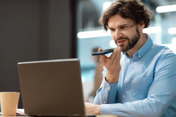 Sorrindo homem trabalhando e falando ao telefone no escritório — Fotografia de Stock