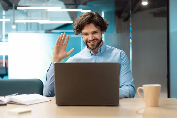 Hombre de negocios usando portátil saludando la mano haciendo videollamada — Foto de Stock