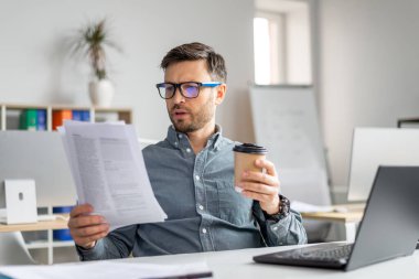 Ofiste belgelerle ve belgelerle çalışan konsantre orta yaşlı işadamı analist müdürü