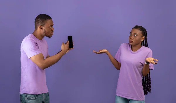 Angry black man checking his girlfriend mobile phone —  Fotos de Stock