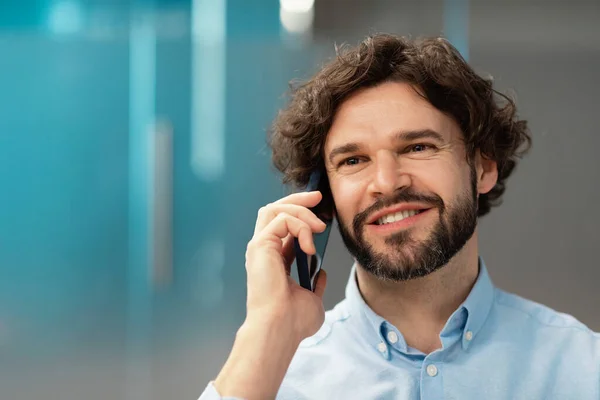 Hombre de negocios sonriente trabajando y hablando por teléfono en la oficina —  Fotos de Stock