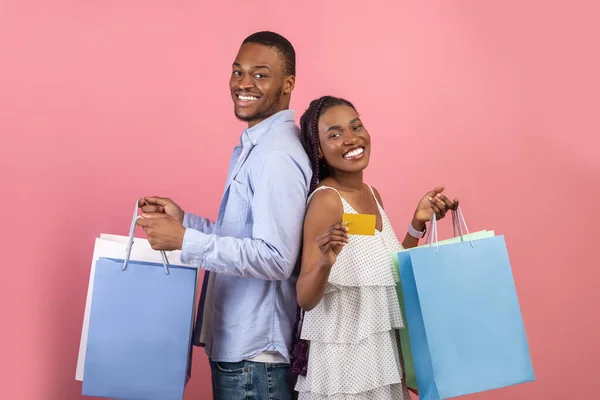 Porträtt av glada svarta par som innehar kreditkort och väskor — Stockfoto