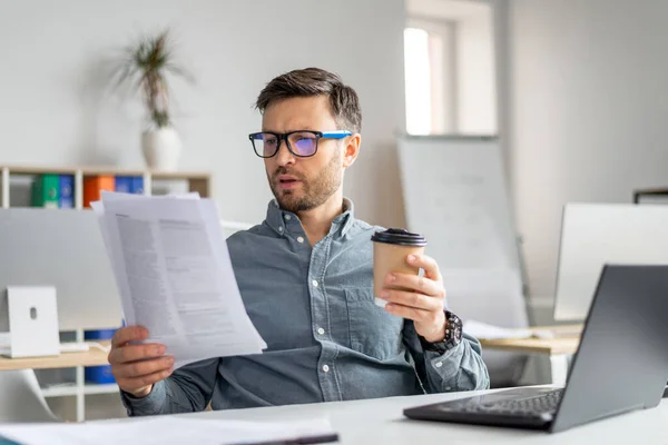 Geconcentreerde analist van middelbare leeftijd die werkt met documenten en papieren op de werkplek — Stockfoto