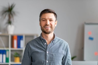 Ofiste poz veren olgun iş adamının yakın plan portresi, resmi giyinmiş orta yaşlı yakışıklı bir yönetici.