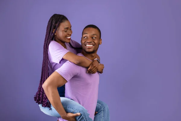 Afro-Amerikaanse man geven piggyback rit voor zijn vrouw — Stockfoto