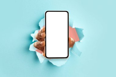 Beyaz, boş, akıllı telefon ekranı gösteren siyah bir insan kağıdı delip geçiyor.