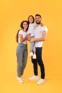 Mutlu Orta Doğulu Ebeveynler Sarı Arkaplan Üzerine Kızlarını Sarılırken