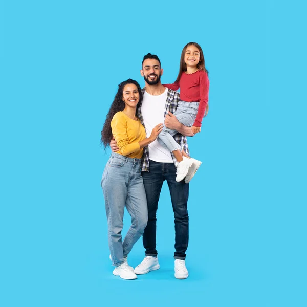 Sorrindo família do Oriente Médio em pé juntos posando sobre fundo azul — Fotografia de Stock