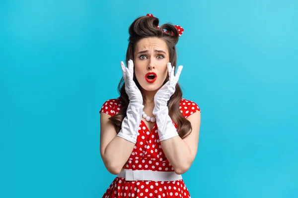 Shocked young pinup woman in retro dress over cannot believe amazing offer or sale, opening her mouth in surprise — Stockfoto
