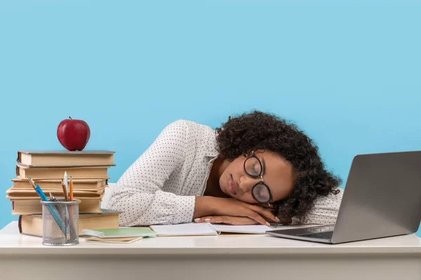 Cansado joven estudiante negro con libros durmiendo frente a la computadora portátil, agotado de la preparación para el examen en línea — Foto de Stock