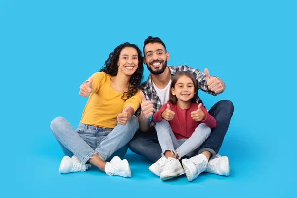 Happy Middle Eastern Family Gesturing Thumbs Up Over Blue Background — Fotografia de Stock
