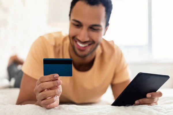 Happy Arabic Guy Shopping Holding Credit Card Using Tablet Indoors —  Fotos de Stock
