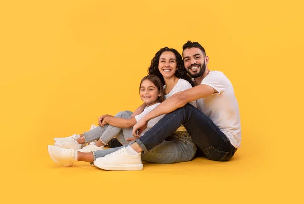 Arabic Father, Mother And Daughter Hugging Sitting Over Yellow Background — Fotografia de Stock