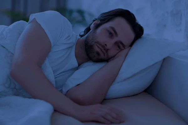 Depressed man cant sleep at night, laying in bed alone — Stock Fotó