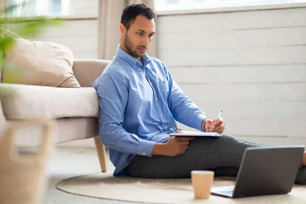 Portrait of Arab man using laptop and writing — Stockfoto