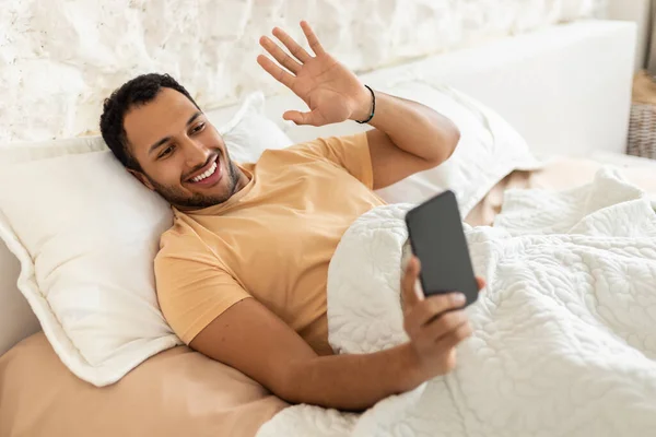 Middle Eastern Guy Making Video Call Via Phone In Bedroom — Foto Stock