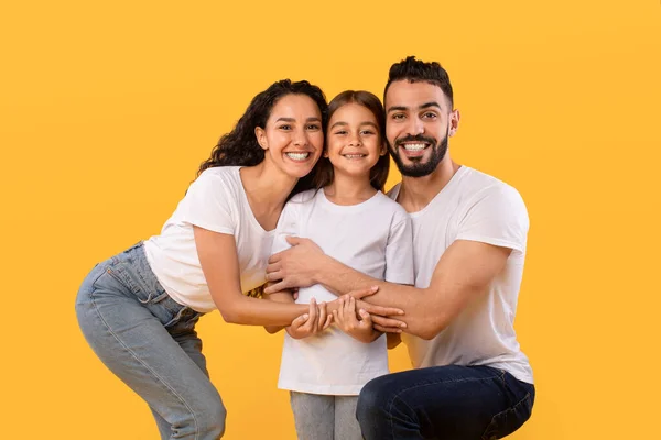 Pais do Oriente Médio Abraçando a Filha Segurando as Mãos, Fundo Amarelo — Fotografia de Stock