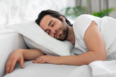 Closeup of young man sleeping in bed at home