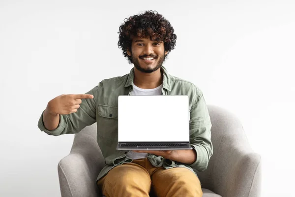 Hombre indio feliz con portátil apuntando a la pantalla vacía —  Fotos de Stock