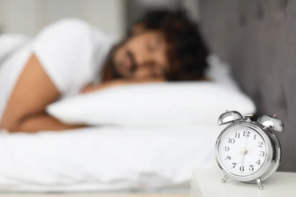 Selective focus on alarm on bedside over sleeping man — Stock fotografie