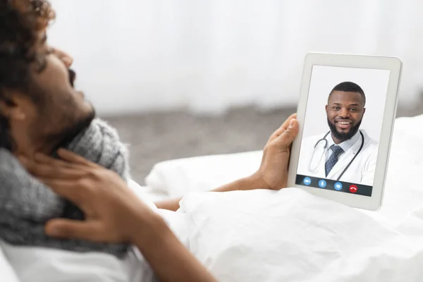 Guy having video conference with doctor while staying in bed — Photo