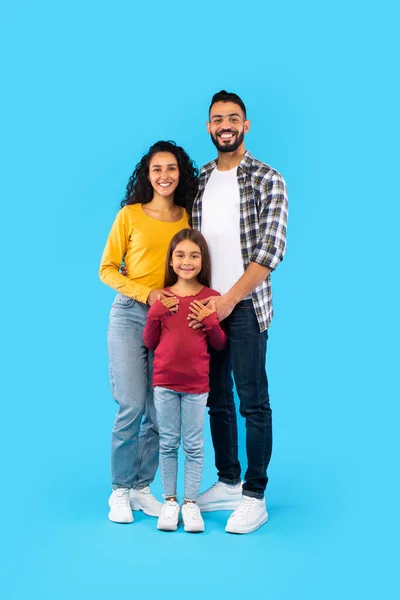 Cheerful Arabic Family Of Three Posing Embracing, Blue Background, Vertical — Zdjęcie stockowe
