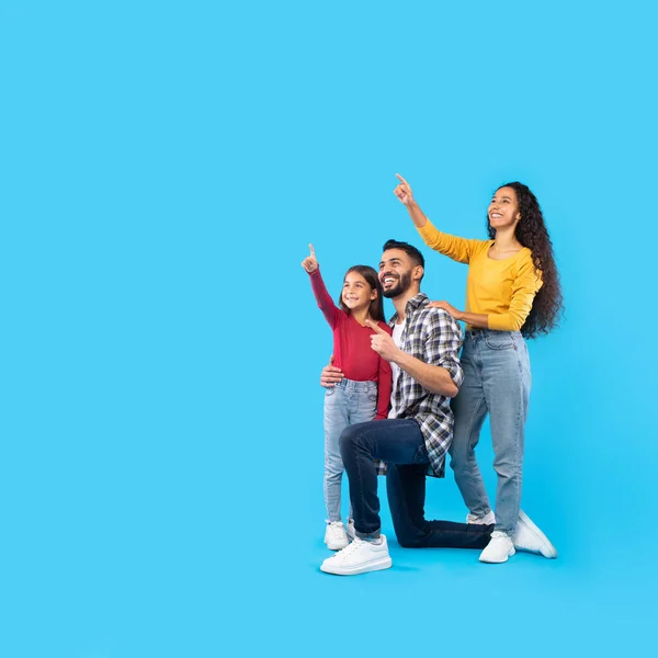 Cheerful Middle Eastern Family Pointing Fingers Upward Over Blue Background — Fotografia de Stock