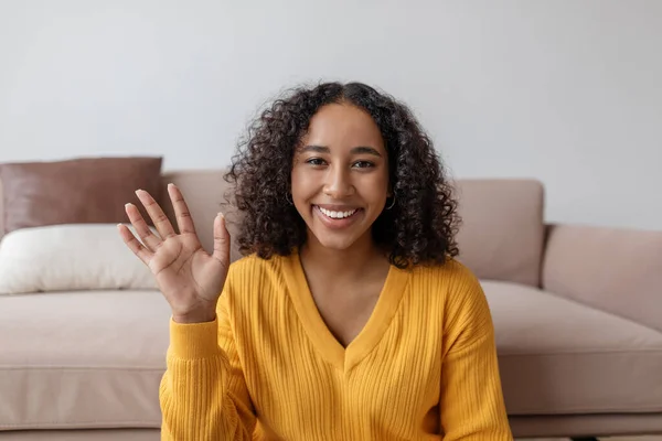 Positive young black woman waving at webcam, talking to family or friend on laptop from home — Foto Stock