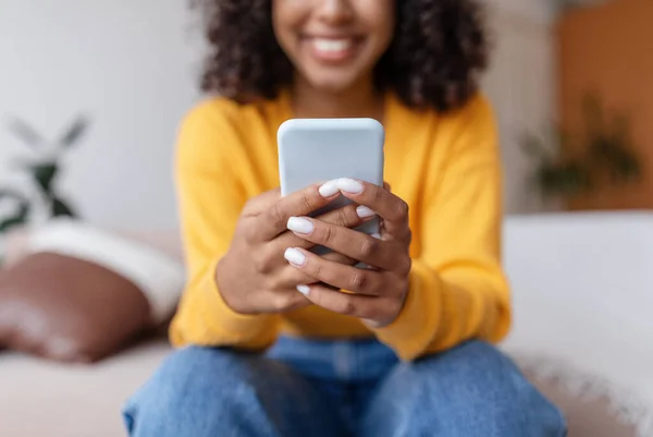 Unrecognizable young black woman using mobile phone, having online video call, communicating in social network at home — Foto Stock