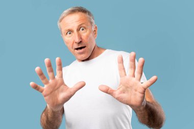 Stüdyoda kameraya bakan korkmuş yetişkin bir adam.