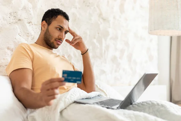 Middle Eastern Man Using Laptop And Credit Card In Bedroom — Stock Fotó