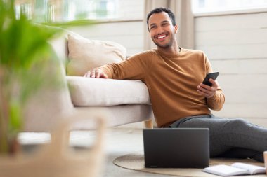 Genç bir Arap 'ın elinde cep telefonu var.