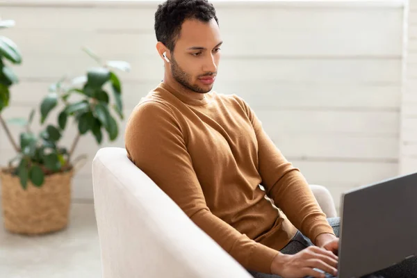 Arab férfi használ laptop ül kanapén otthon — Stock Fotó
