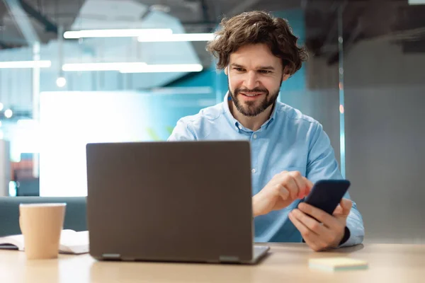 Retrato del hombre sonriente usando smartphone y PC en la oficina — Foto de Stock