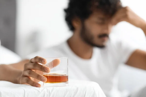 Glass with alcohol in bearded dark-skinned guy hand — Stock Fotó