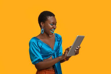 Happy african american lady using modern digital tablet