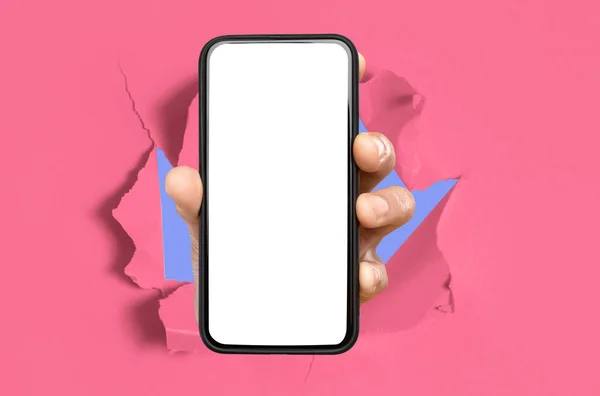 Person showing white empty smartphone screen breaking through paper — стоковое фото