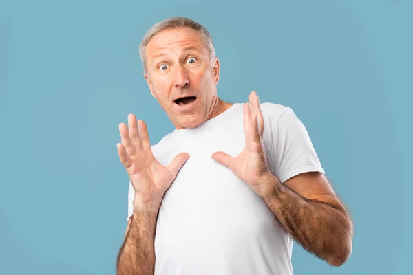 Scared mature man staring at camera at studio — Photo