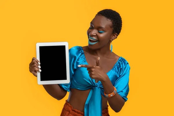 Возбужденная черная женщина указывает на цифровой планшет, макет — стоковое фото