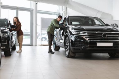 Mutlu milenyum çifti lüks arabaları kontrol ediyor, yeni otomobil seçiyor, galeride araba alıyor ya da kiralıyor, kopyalama alanı yaratıyor.