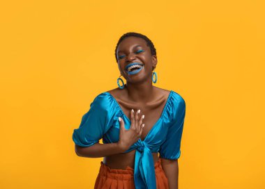 Zevkli stil sahibi siyahi kadın gülüyor sarıya, kopyalama alanına.