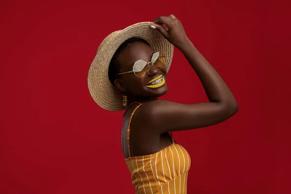 Cool black woman in summer outfit posing on red — Stock Photo, Image