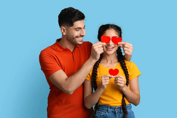 Romantic Arab Couple Holding Red Paper Hearts And Having Fun Together — Foto de Stock