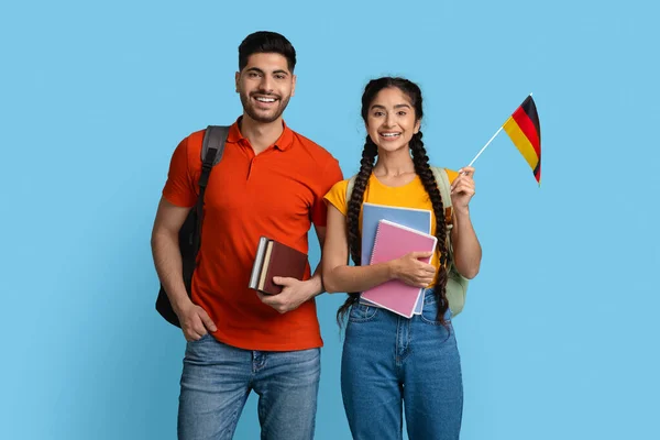 Istruzione all'estero. Ritratto di felice giovane arabo studenti coppia holding tedesco bandiera — Foto Stock